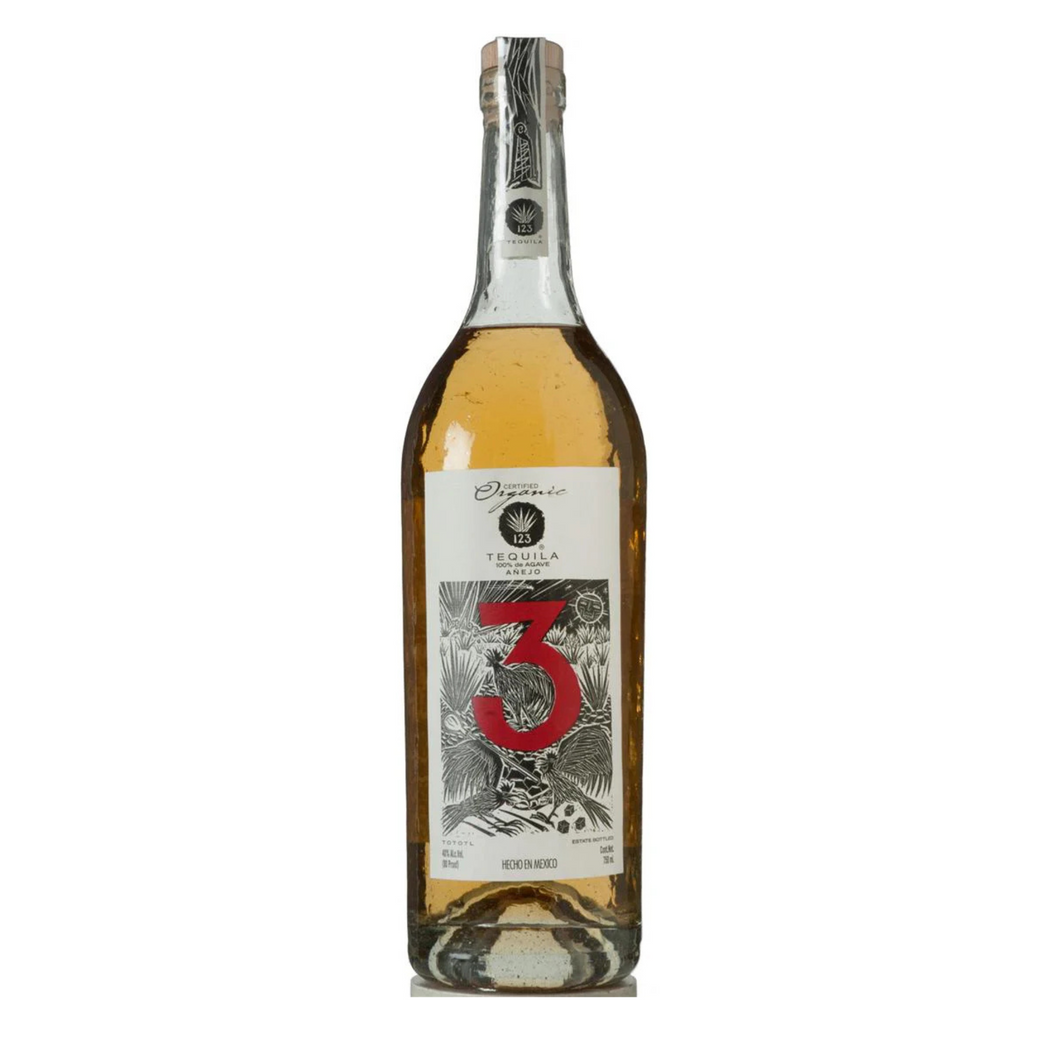 123 Organic AÃ±ejo Tequila Tres bottle displayed elegantly with a rich amber hue, showcasing its premium label and crafted design.