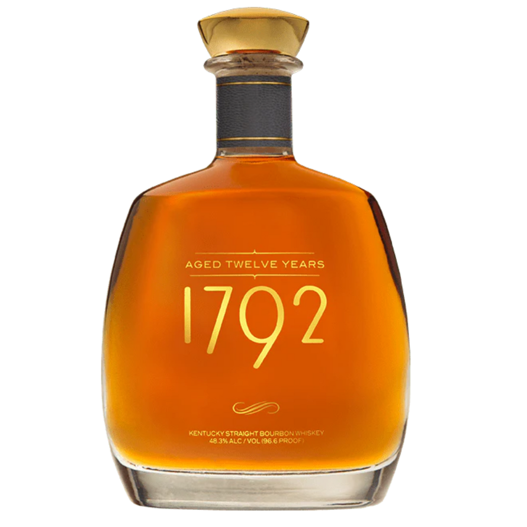 Bottle of 1792 Aged 12 Years bourbon whiskey with a rich amber hue, featuring an elegant label and gold accents, placed on a wooden surface.