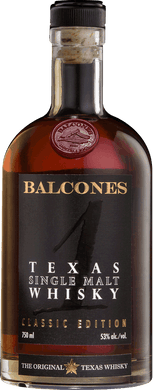 A bottle of Balcones Texas Single Malt Whisky displayed on a wooden table, surrounded by a warm amber glow, emphasizing its rich and smooth character.