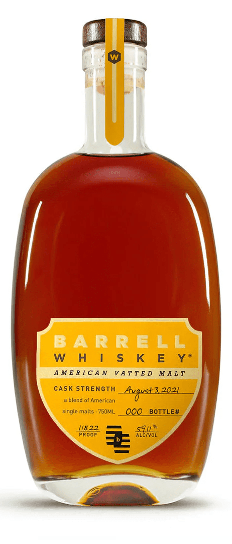 Bottle of Barrell American Vatted Malt whiskey placed on a wooden table, surrounded by polished glassware and warm ambient lighting.